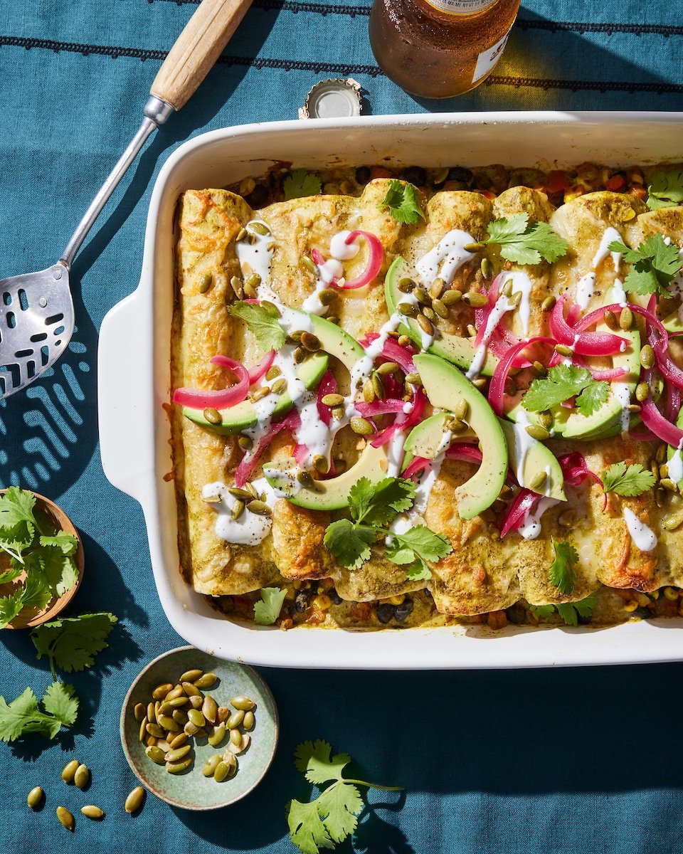 black bean enchiladas in a pan from the Ambitious Kitchen Cookbook