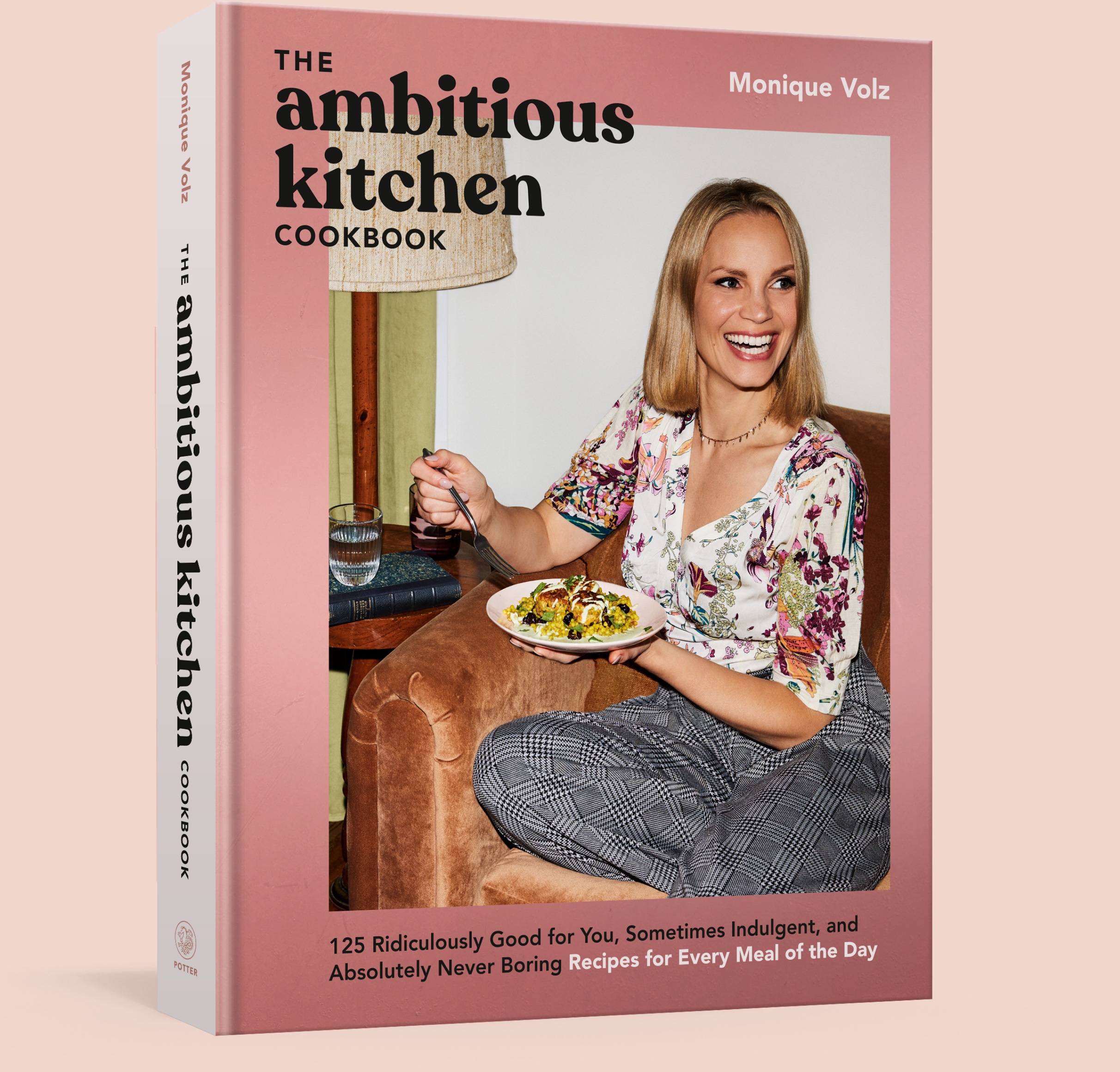 The Ambitious Kitchen Cookbook on a pink background