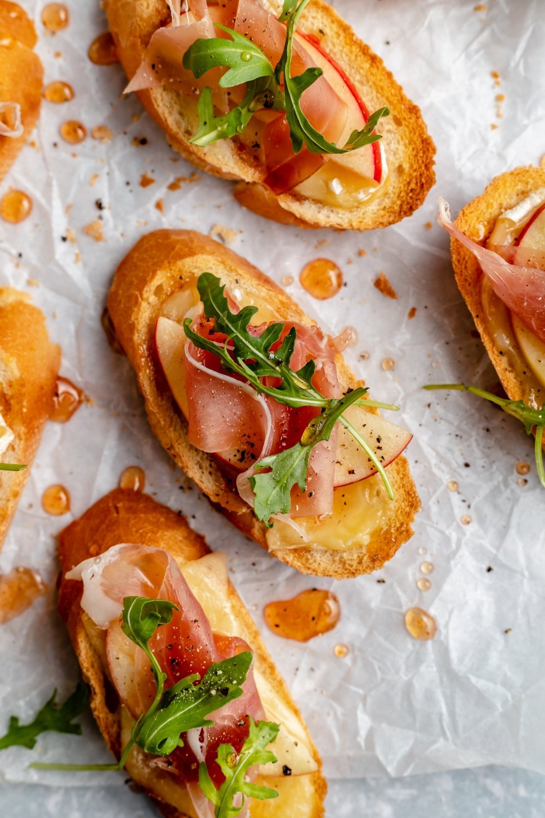 brie and apple crostini with prosciutto and arugula