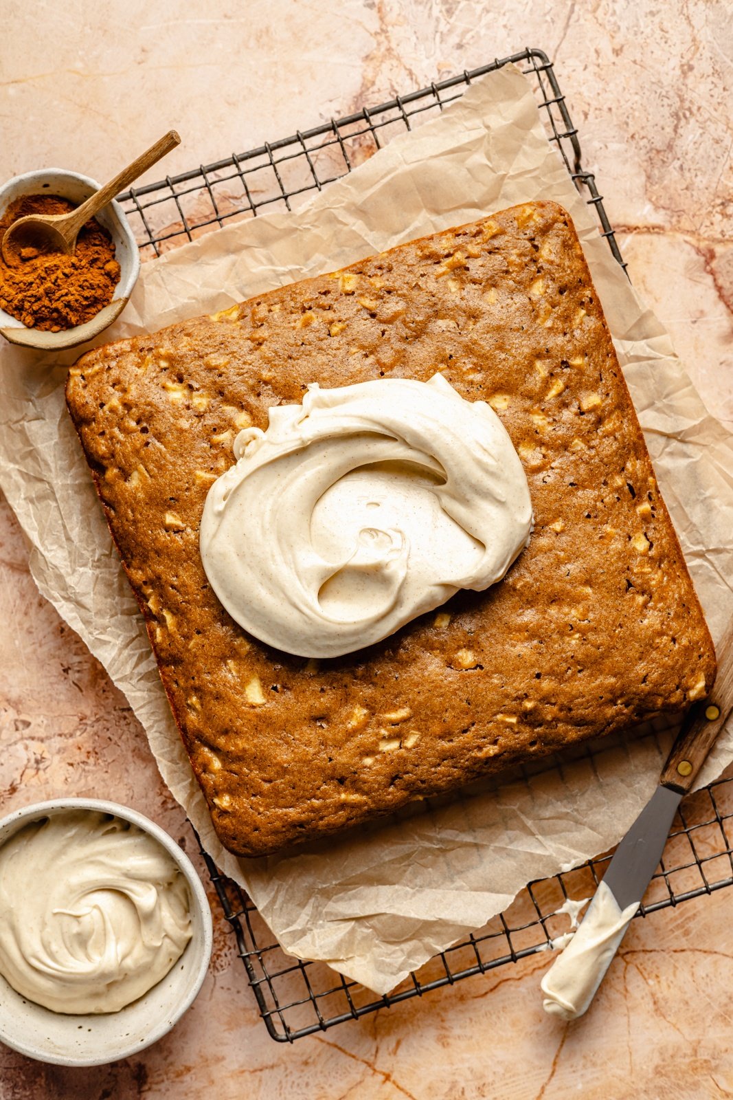 frosting an apple snacking cake on a wire rack