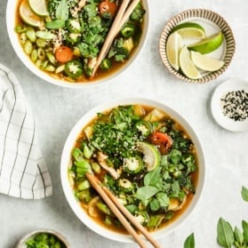 two bowls of asian chicken soup with chopsticks