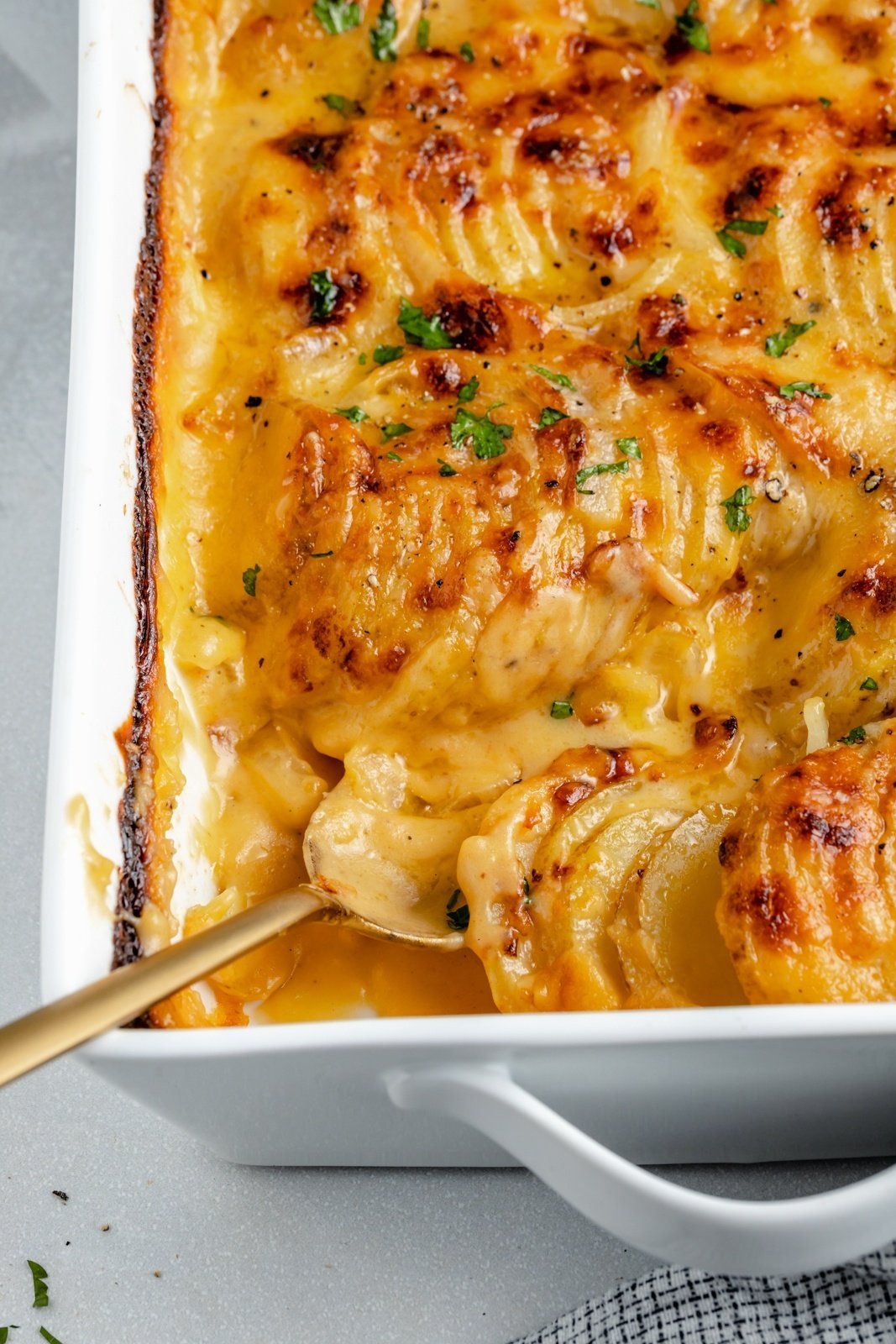 homemade potatoes au gratin in a baking dish with a spoon