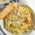 bacon brussels sprouts spaghetti in a bowl with a slice of bread