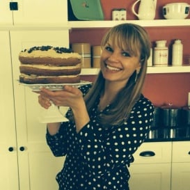 Monique from Ambitious Kitchen holding a cake