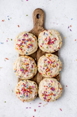 six gluten free birthday cake cookies on a wooden board