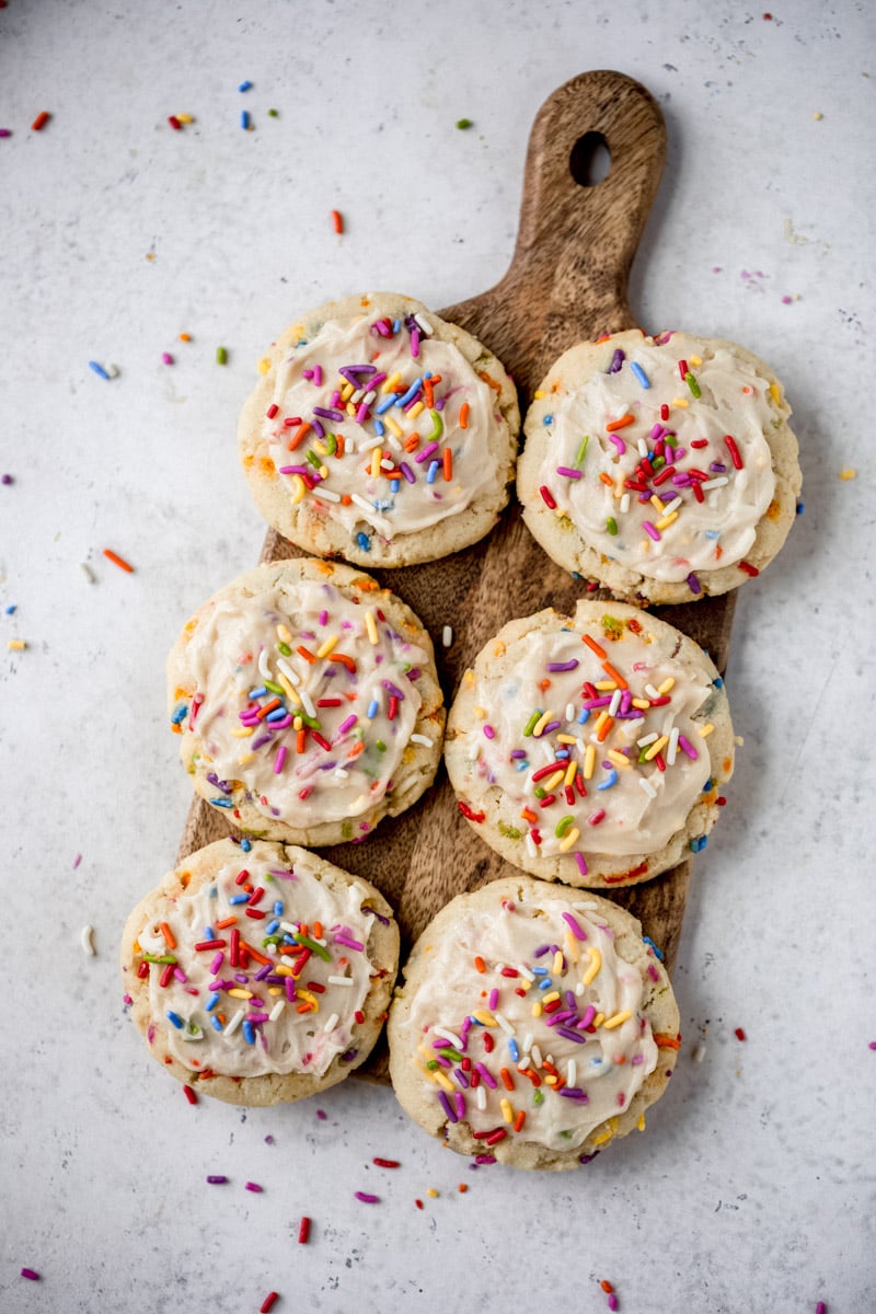 6 dairy free birthday cake cookies on a wooden board