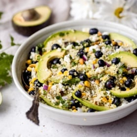 avocado blueberry salad in a bowl with a spoon