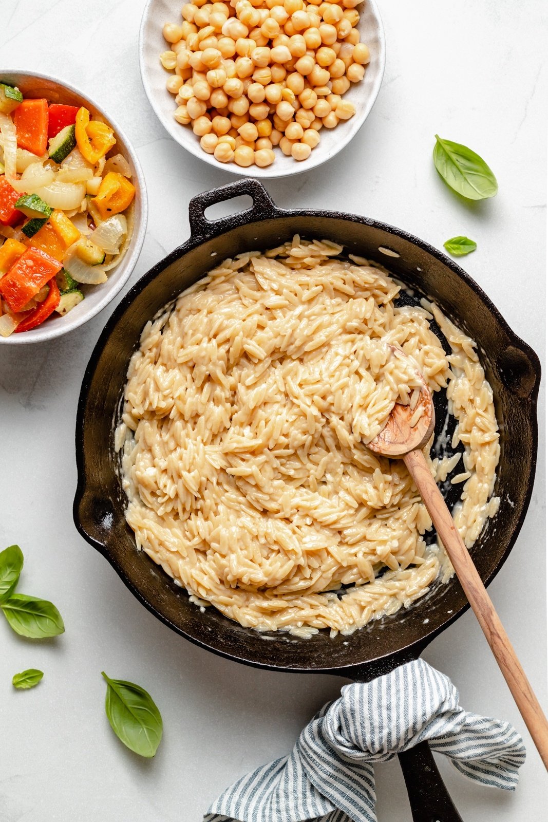 orzo in a skillet next to grilled vegetables