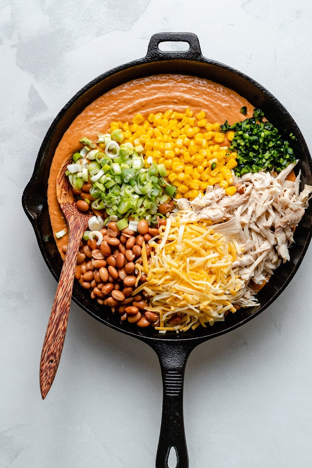 ingredients for chicken enchilada dip in a skillet