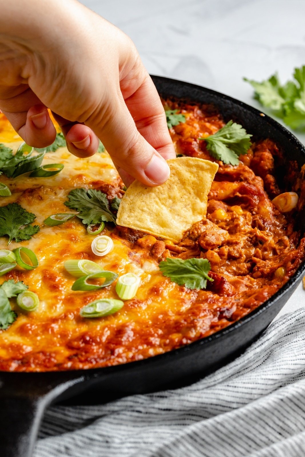 dipping a chip into chicken enchilada bean dip