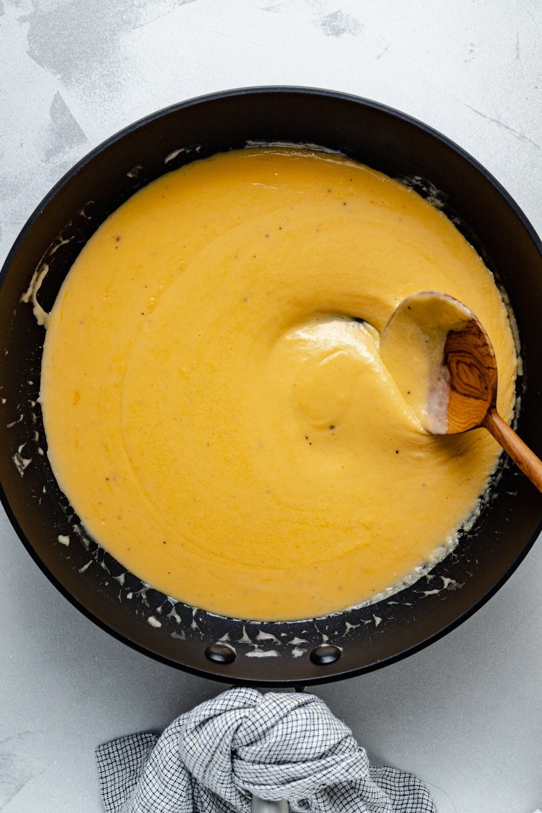 stirring cheese sauce for healthy buffalo mac and cheese