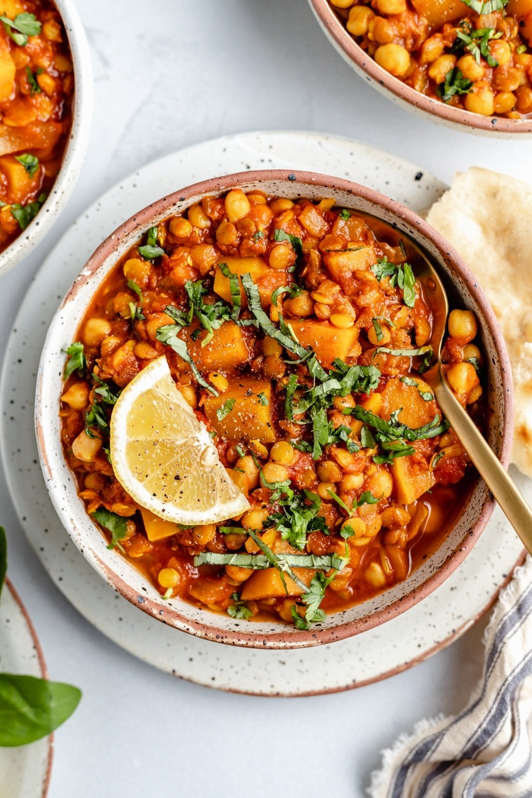 lentil Moroccan stew in a bowl with a lemon wedge