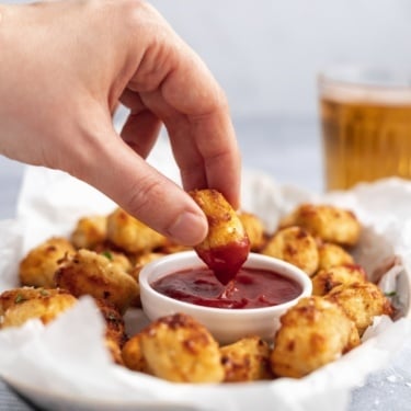 dipping a gluten free cauliflower tot in ketchup