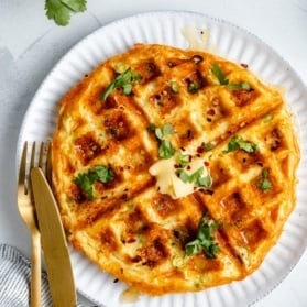 cheese and egg waffle on a plate with butter