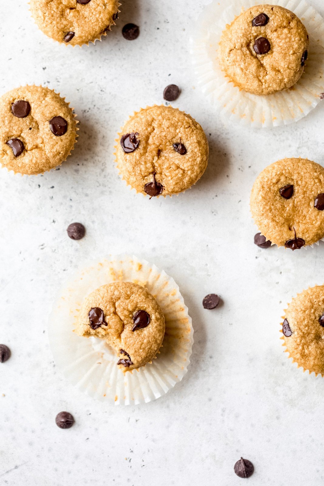 flourless peanut butter chickpea muffins on a grey board with chocolate chips