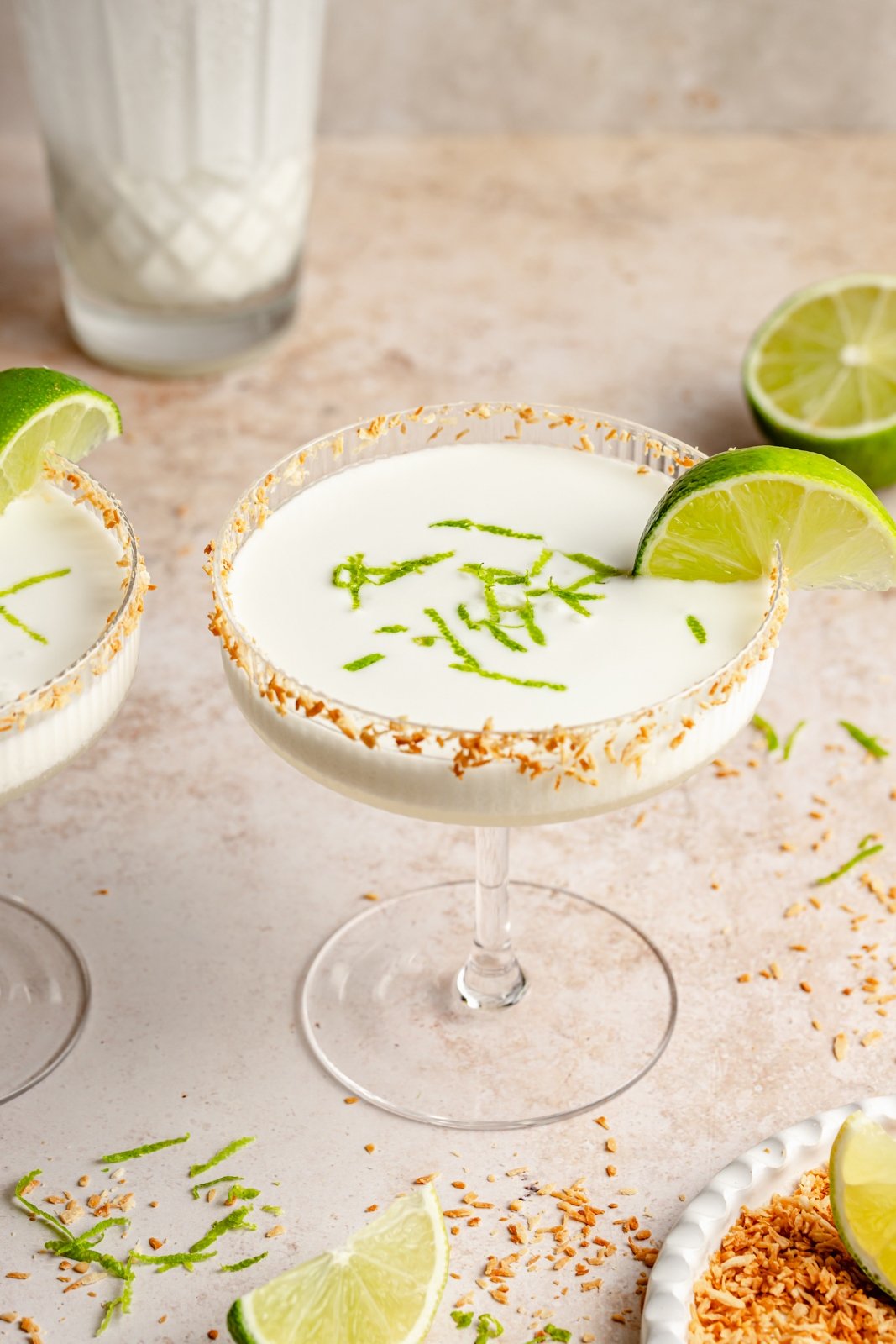 coconut margarita in a glass with a lime wedge