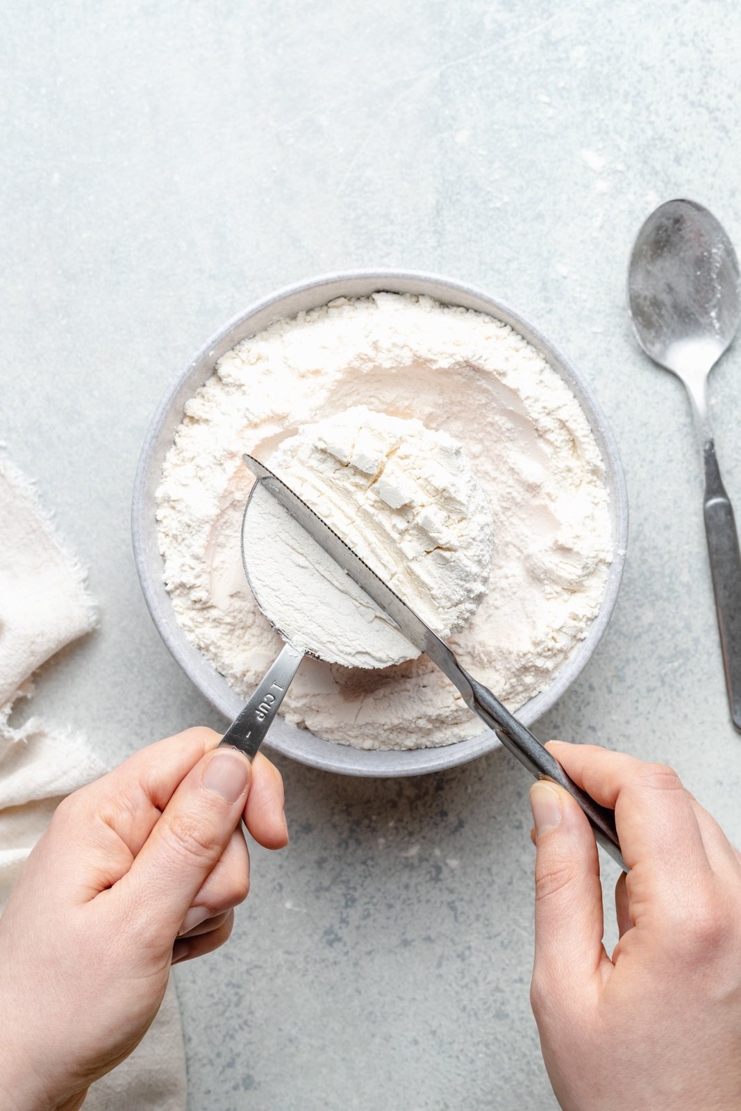 leveling flour in a measuring cup