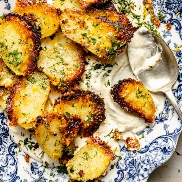 parmesan roasted potatoes in a bowl with garlic feta dip