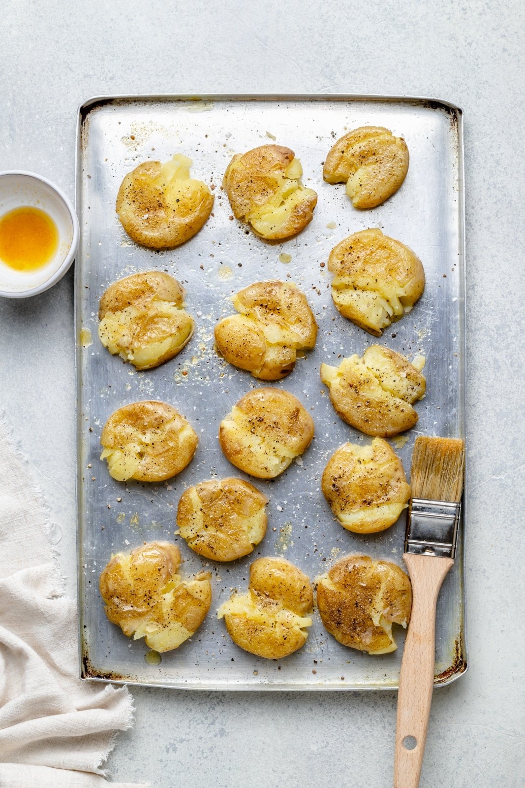 unbaked smashed potatoes on a baking sheet