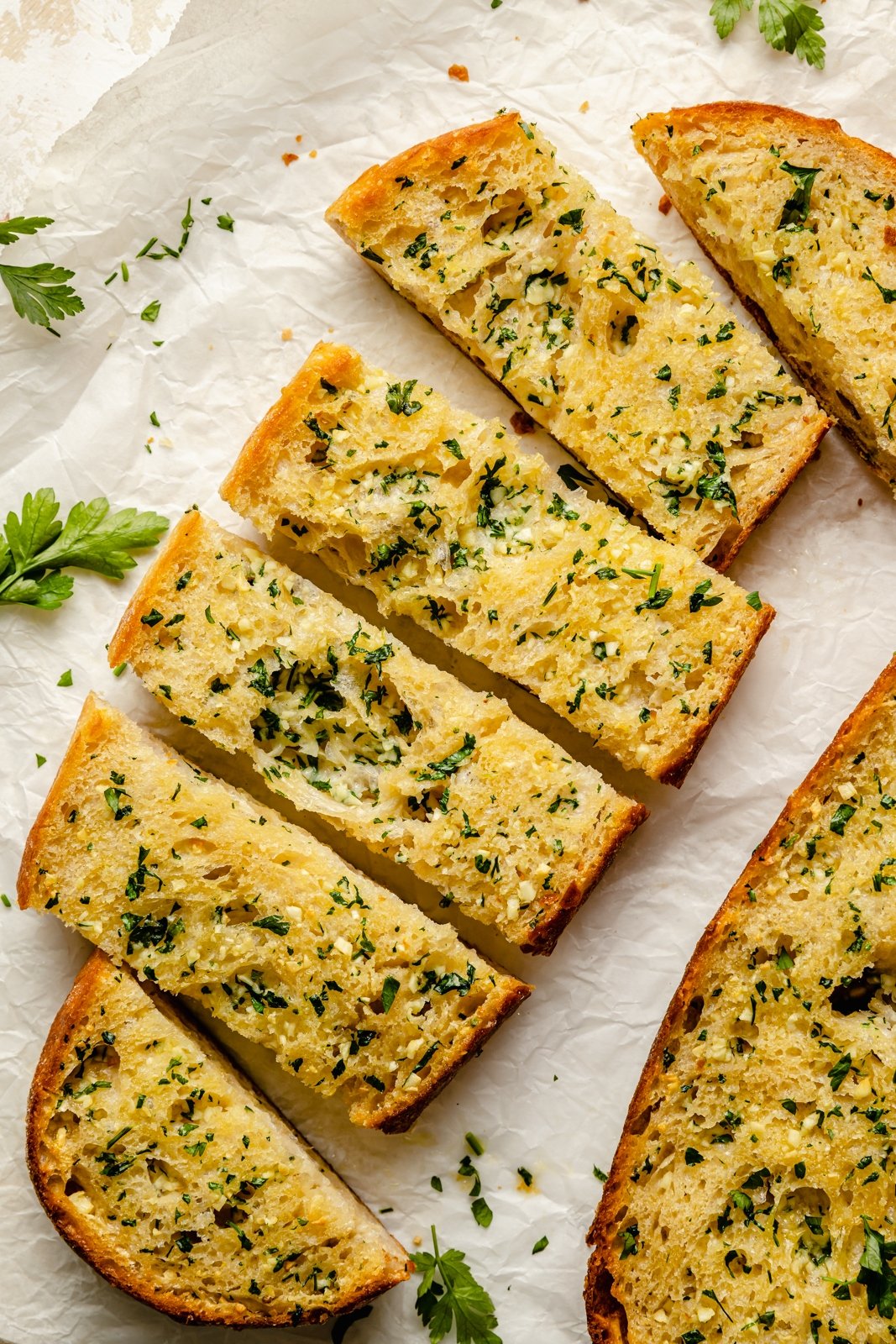 homemade garlic breaad sliced on parchment paper