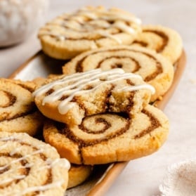 grain free cinnamon roll cookies in a stack with a bite taken out