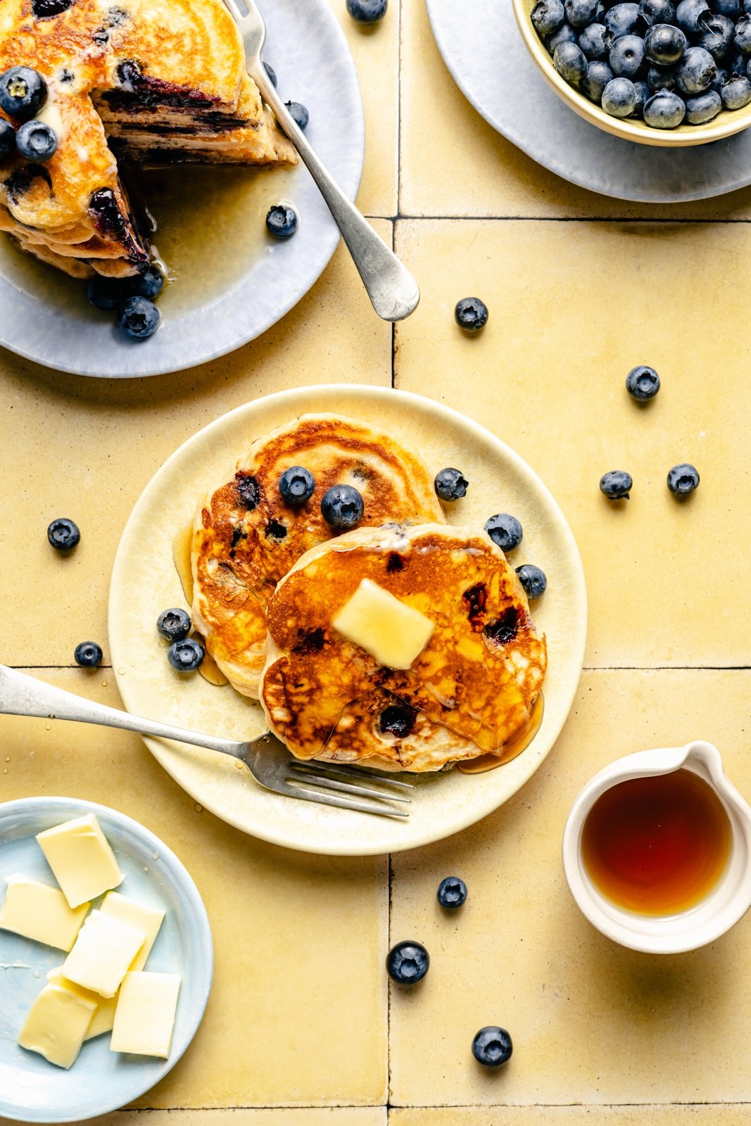 blueberry buttermilk pancakes on a plate with butter