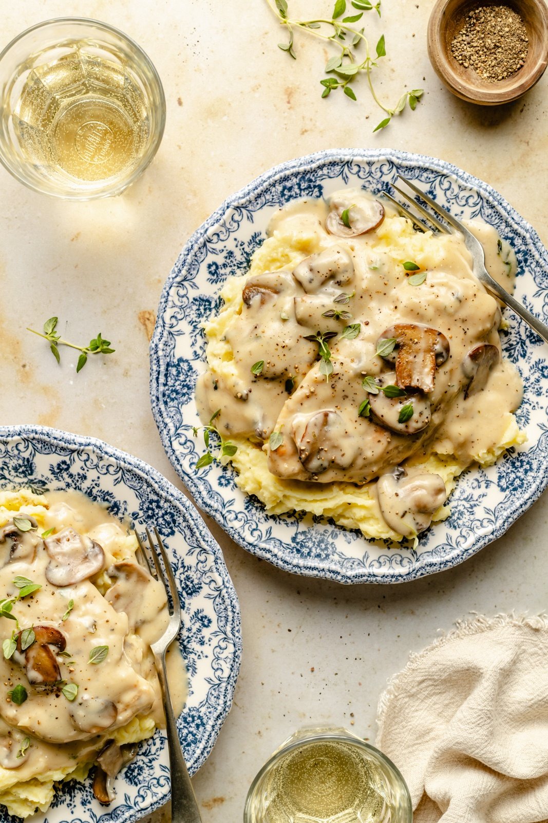 skillet chicken with mushroom gravy over mashed potatoes on two plates