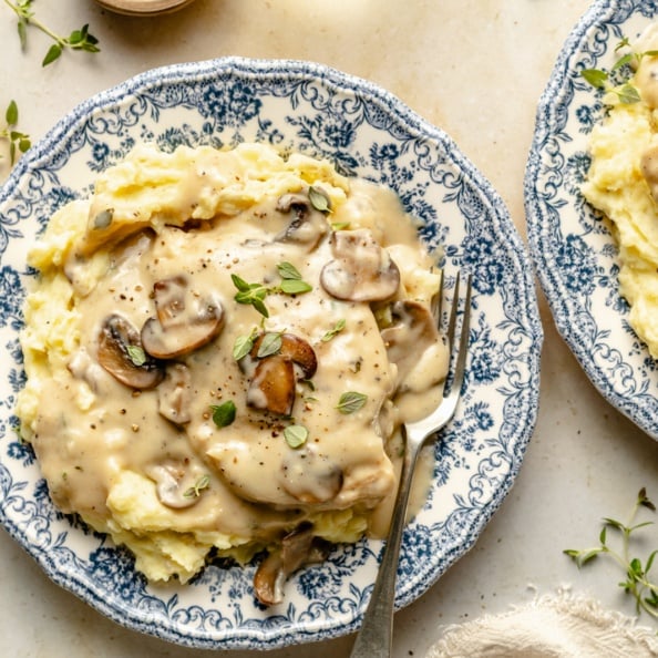 skillet chicken with mushroom gravy over mashed potatoes