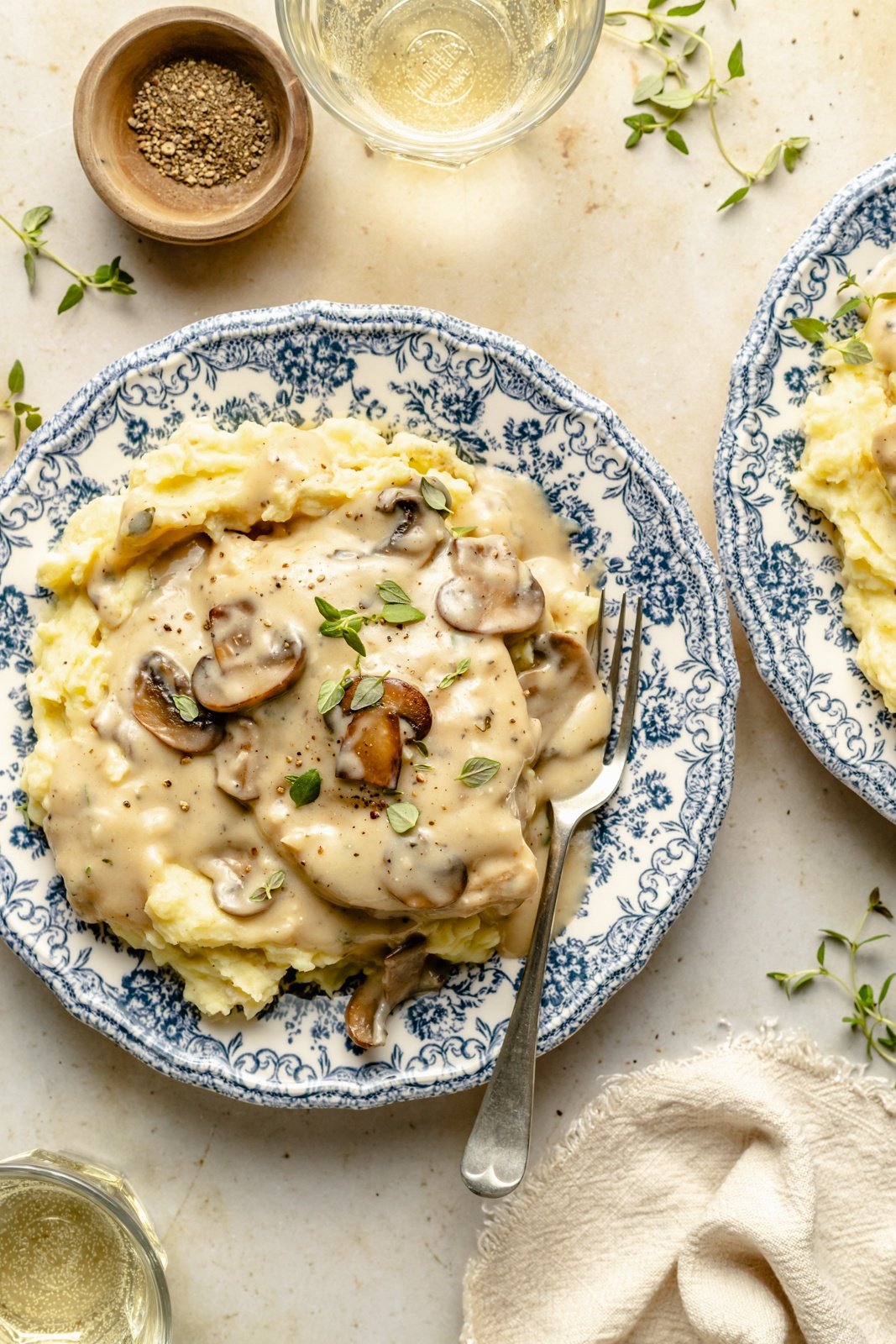 skillet chicken with mushroom gravy on a plate with mashed potatoes