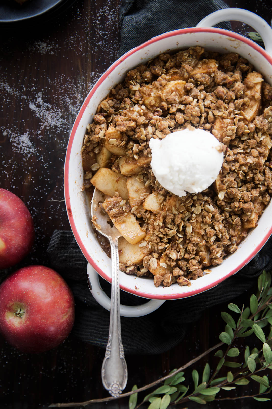 Healthy Apple Crisp in a baking dish with ice cream and a spoon