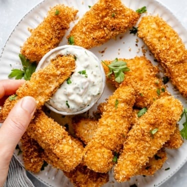 dipping a homemade fish stick in tartar sauce