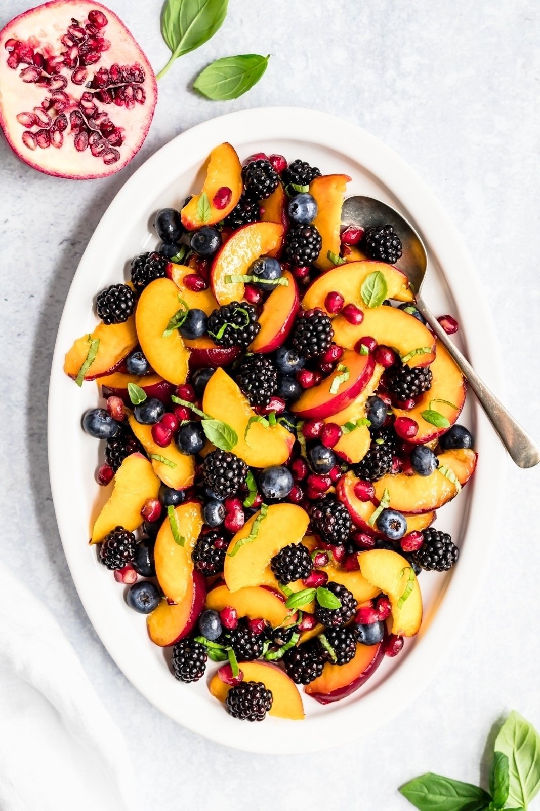 summer peach fruit salad on a platter with basil