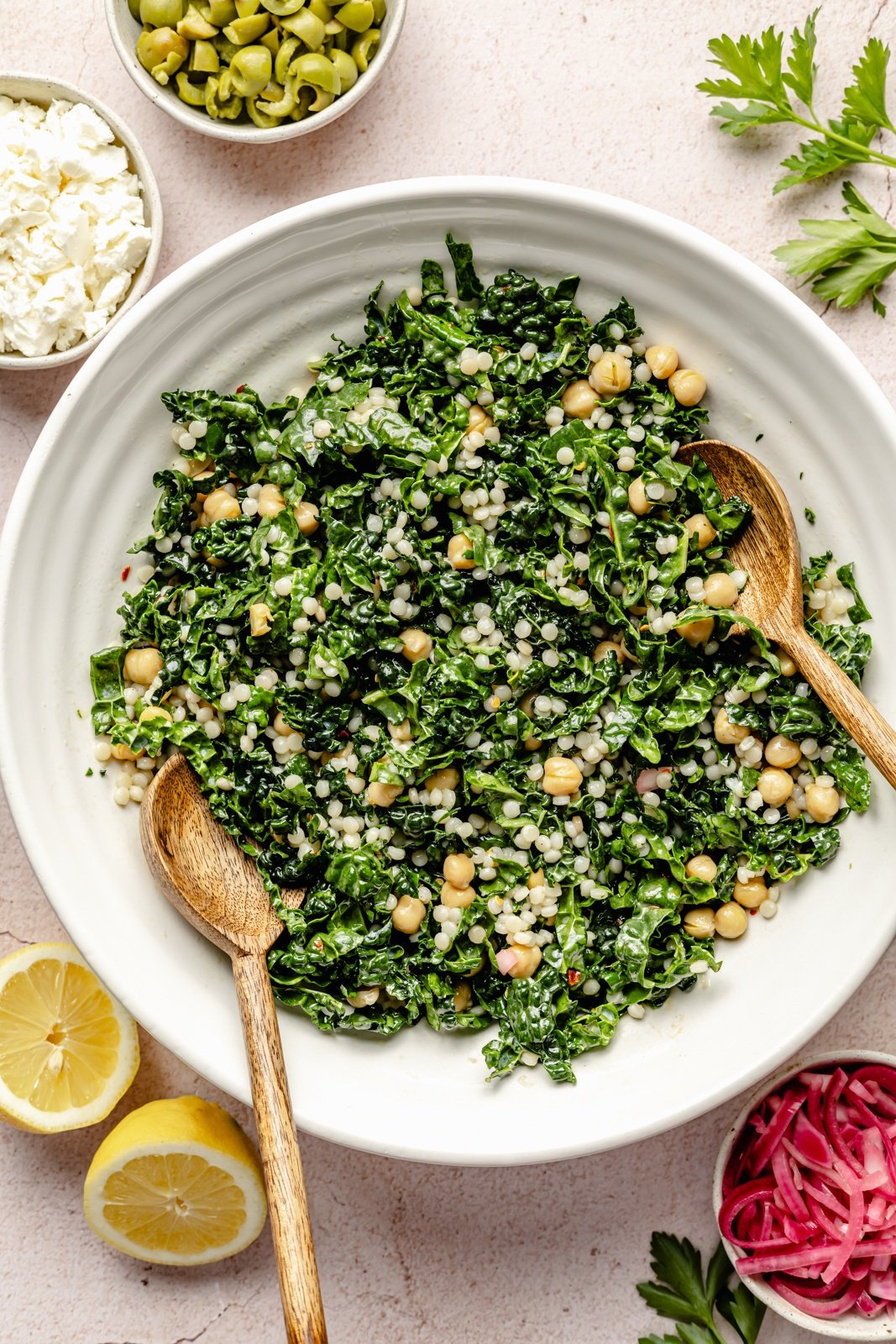 tossing together a kale couscous salad in a bowl