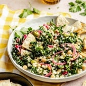 kale couscous salad on a plate with pita chips