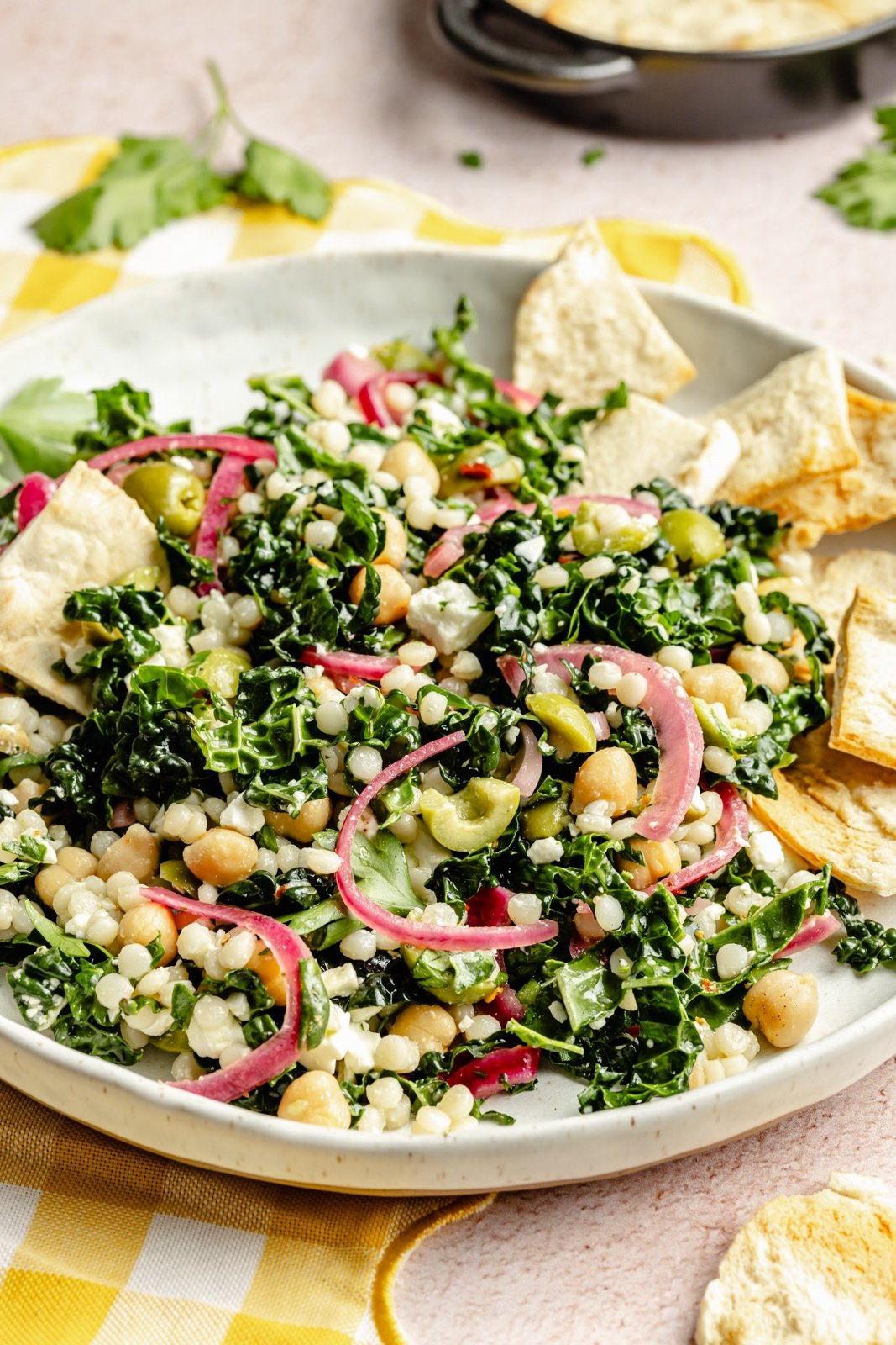 kale couscous salad on a plate with pita chips