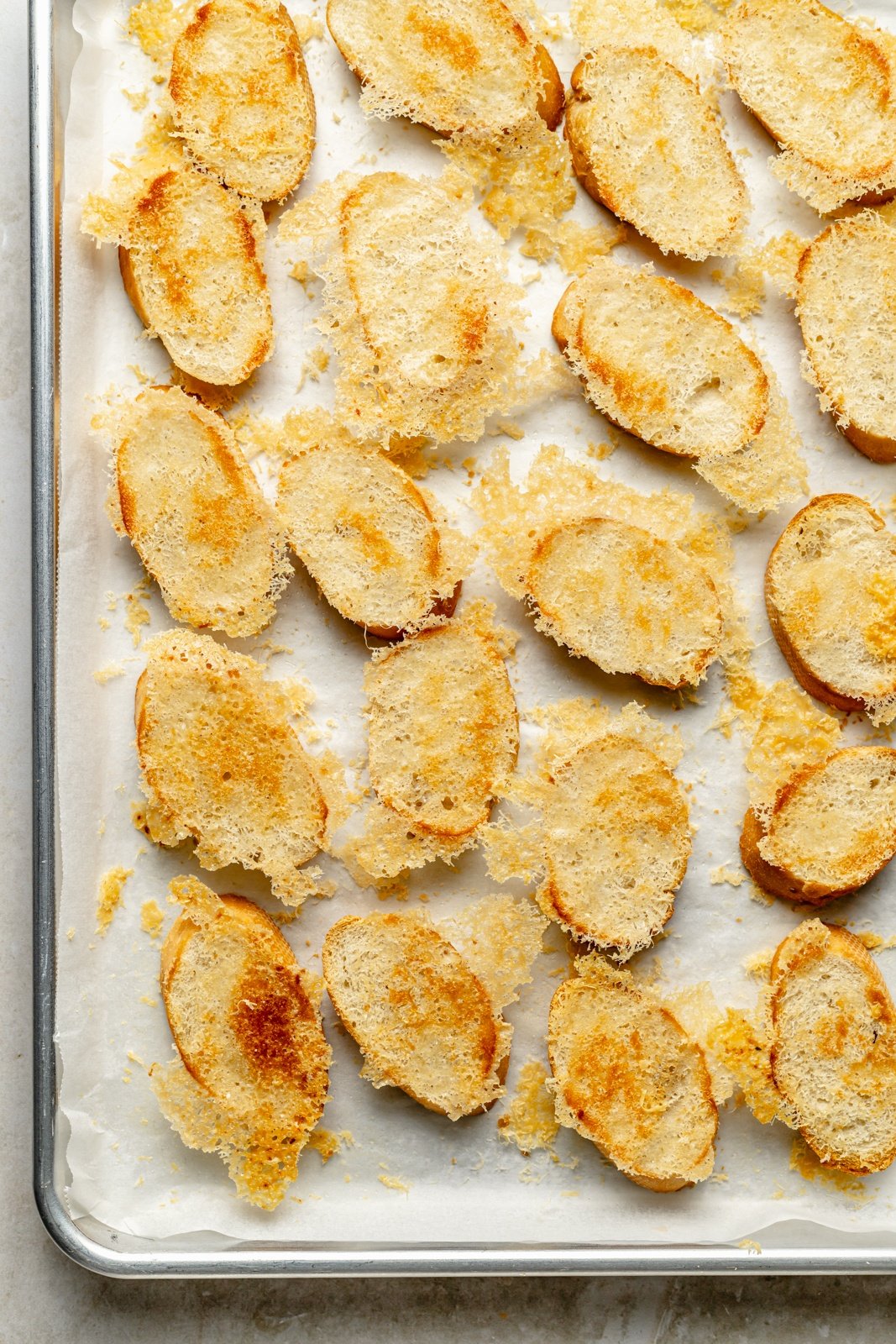 parmesan crusted crostini on a baking sheet