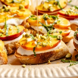 drizzling honey on peach crostini