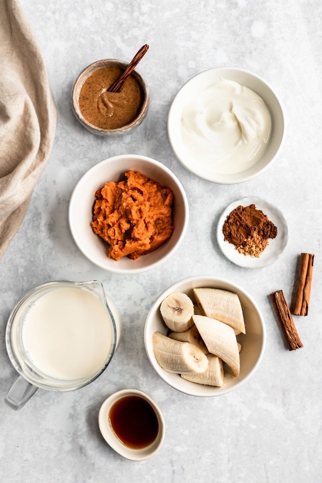 ingredients for a healthy pumpkin smoothie on a grey board