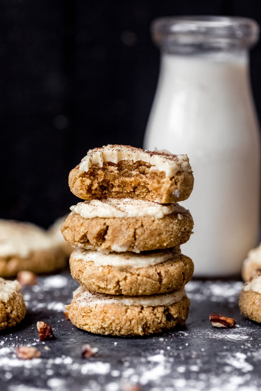 four gluten free pumpkin cookies in a stack in front of a milk bottle