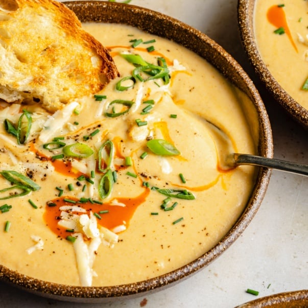 buffalo cauliflower soup in a bowl with a piece of toast