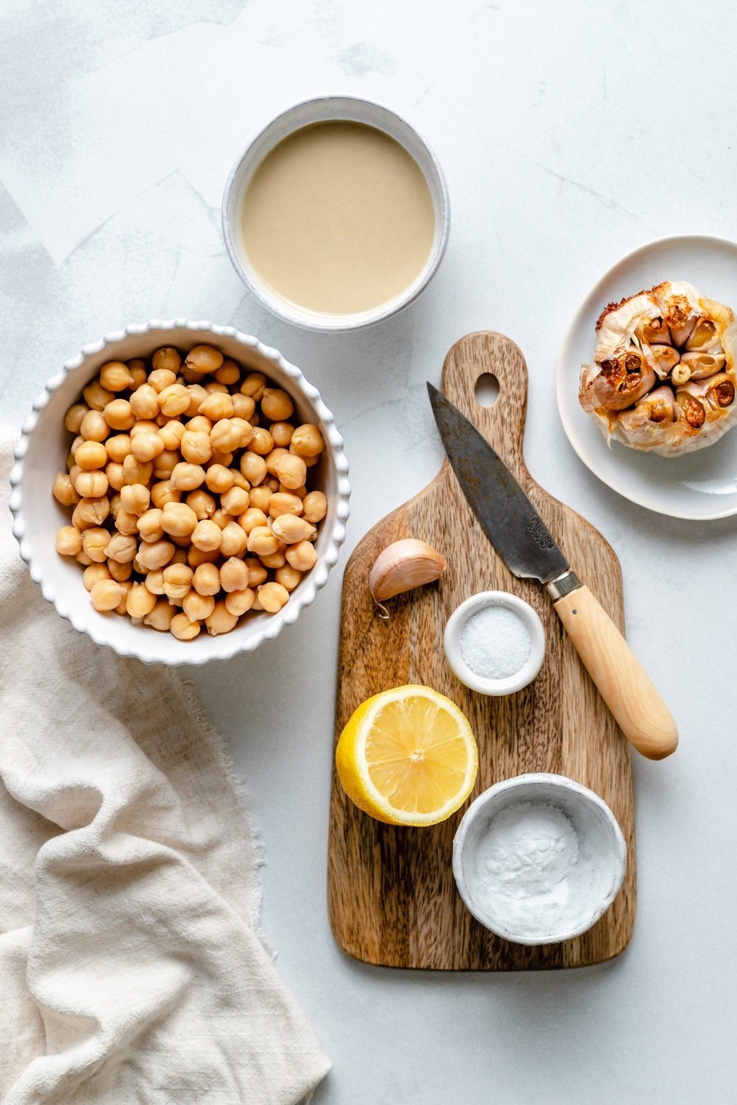 ingredients for homemade roasted garlic hummus on a board