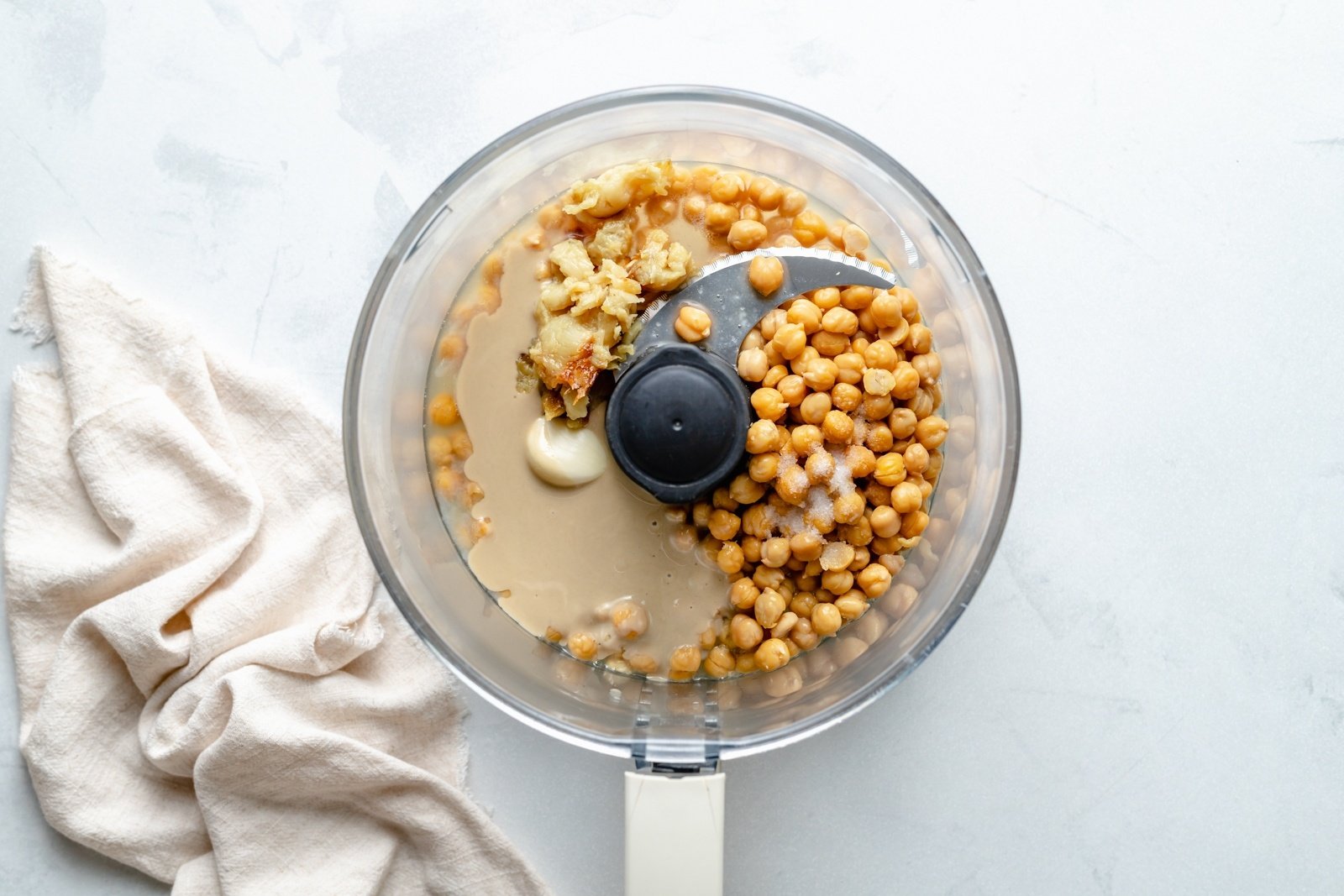 ingredients for roasted garlic hummus in a food processor