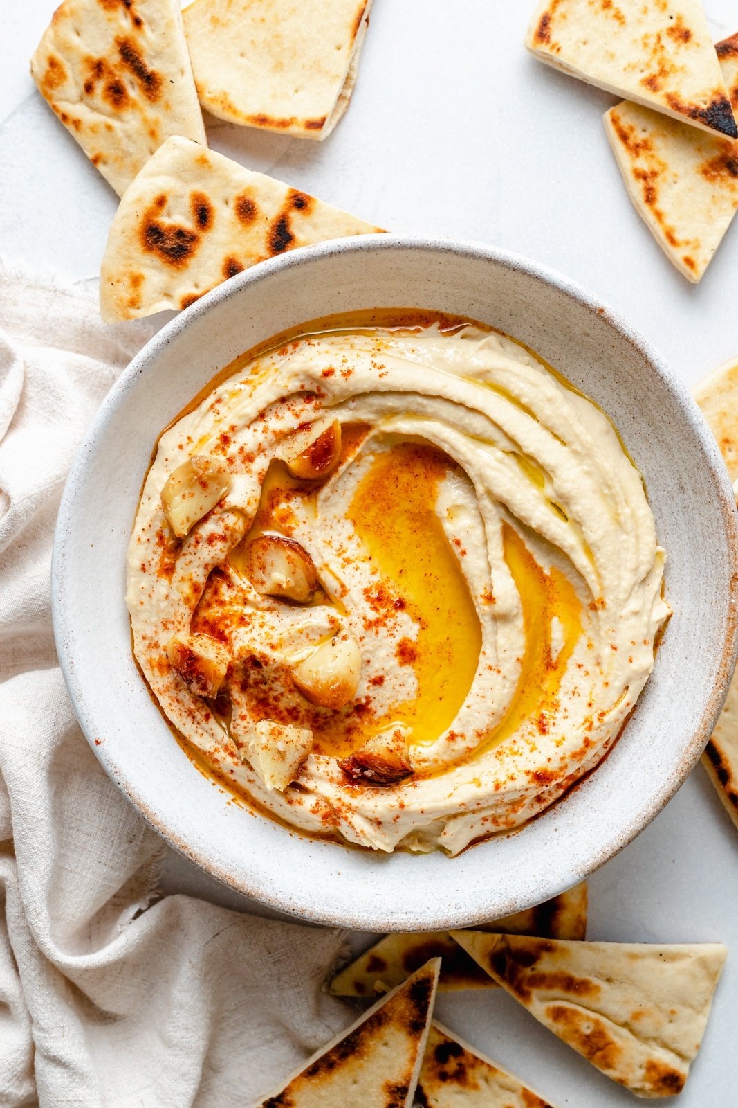 roasted garlic hummus in a bowl next to pita bread