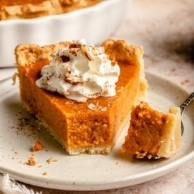 slice of sweet potato pie topped with whipped cream on a plate