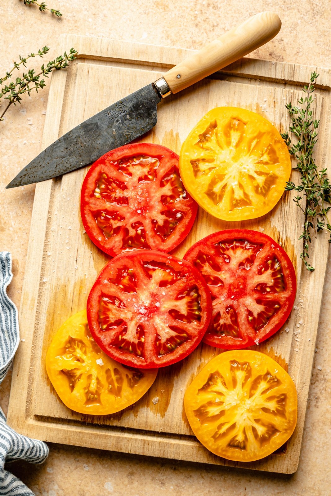 slices of red and yellow tomatoes on a cutting board