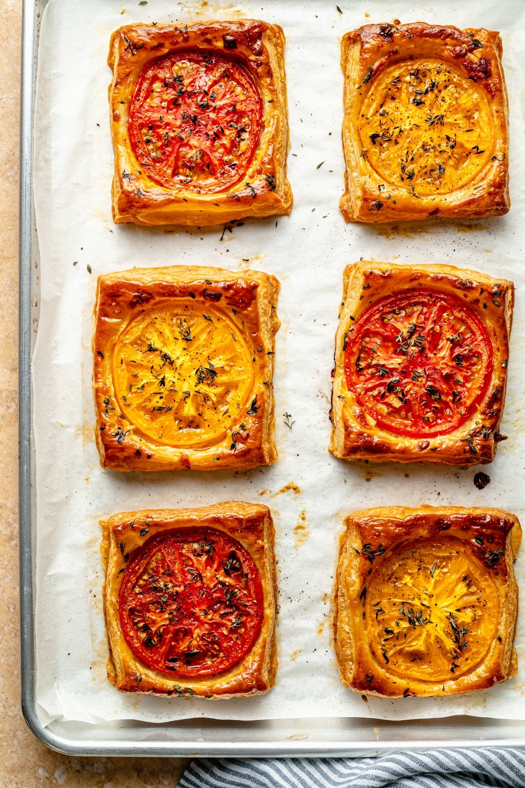 pizza puff pastry tarts on a baking sheet