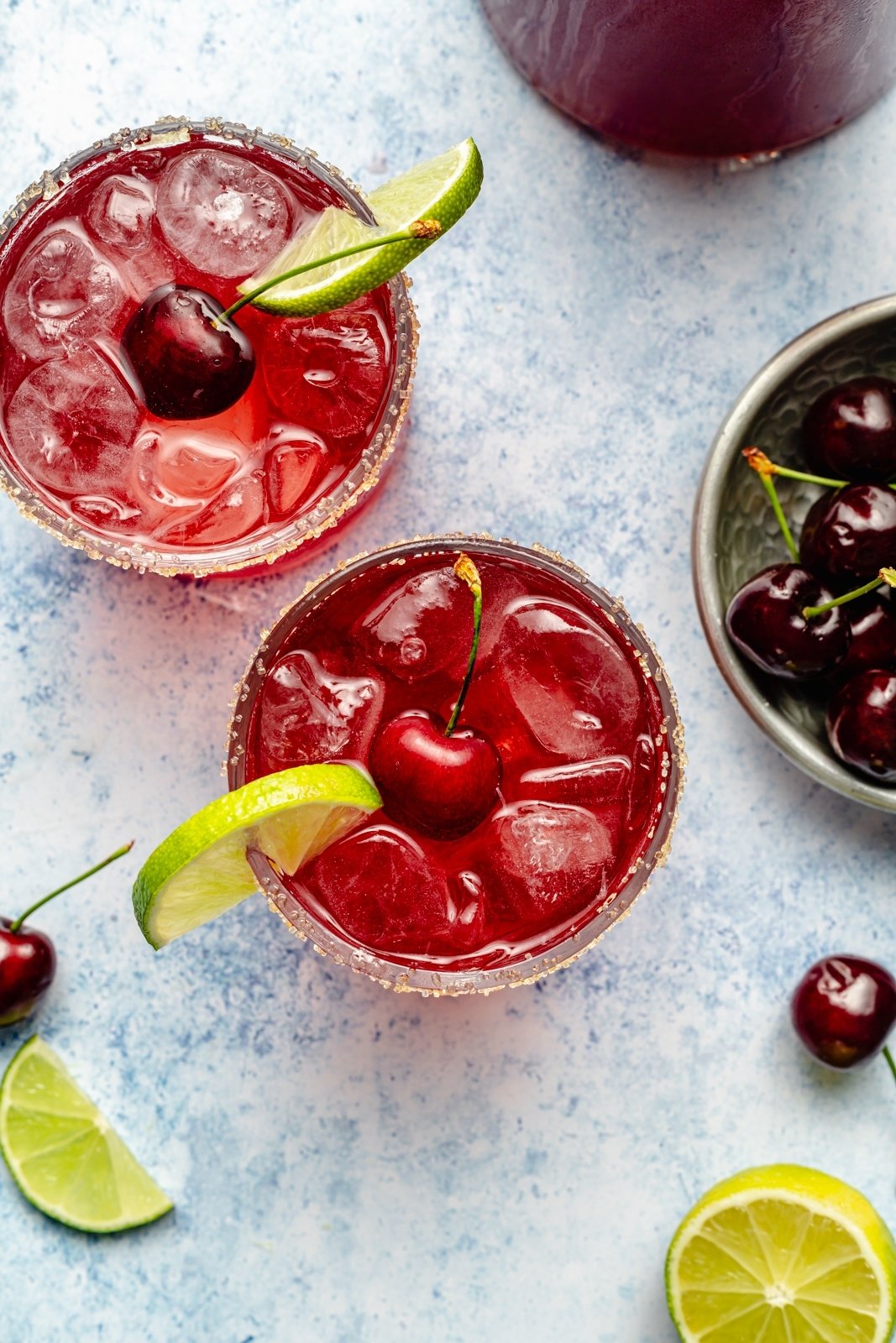 top-down view of two glasses of spiked cherry limeade