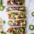 sweet potato black bean tacos lined up on a marble board