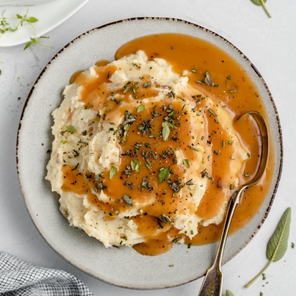 homemade turkey gravy on a plate of mashed potatoes