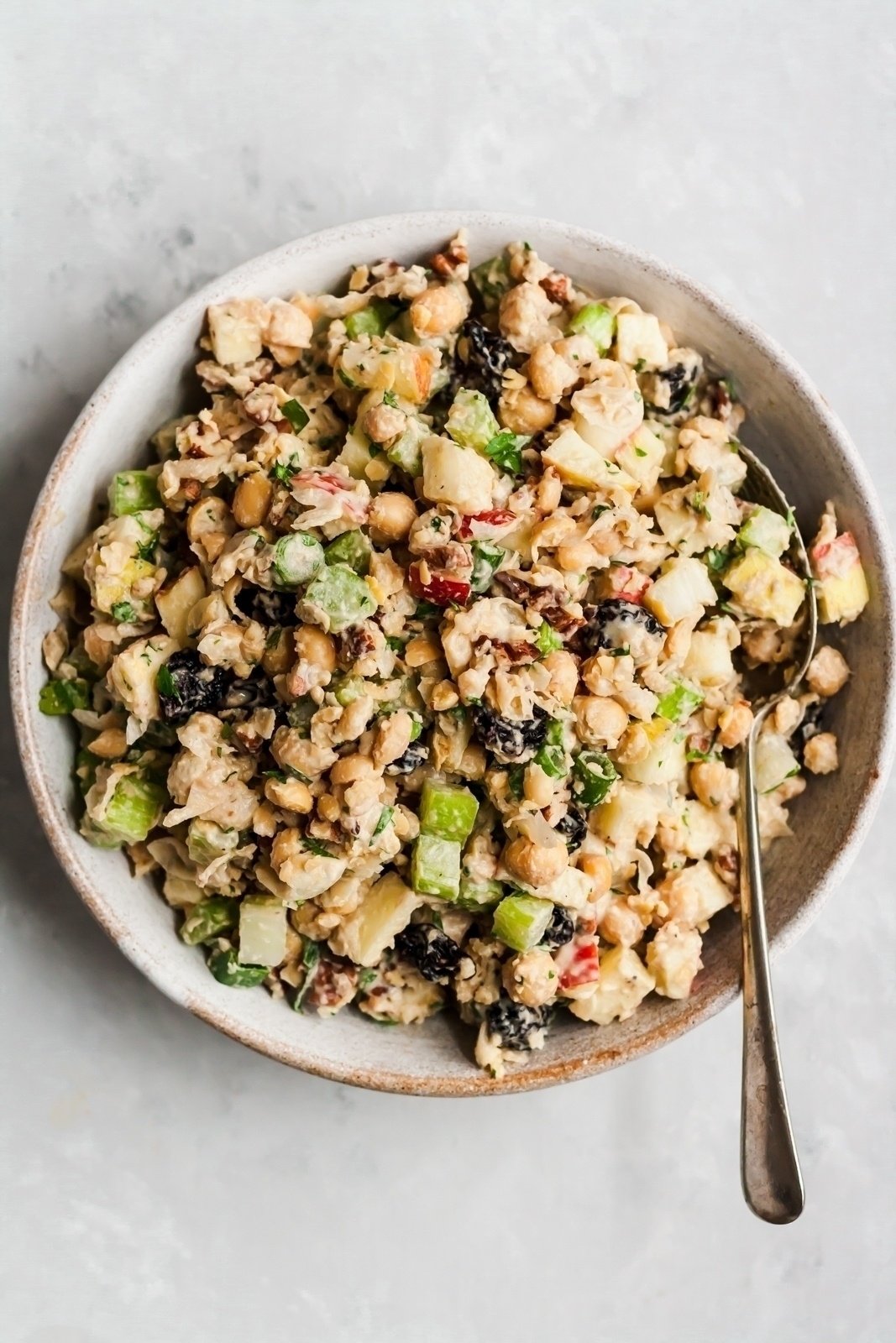 vegan apple chickpea salad in a bowl with a spoon